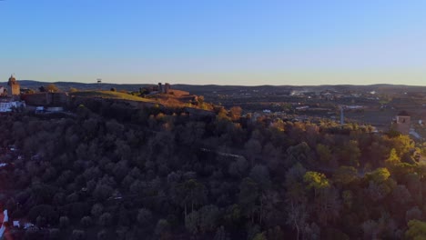 Drone-shot-backing-Drone-shot-backing-out-and-turning,-filming-a-hill-with-some-medievalbuildins-on-in-Alentejo,-Portugal
