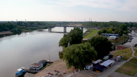 A-Bridge-Crossing-a-River-In-Warsaw,-Poland-Aerial-Gaze-at-Rural-Area