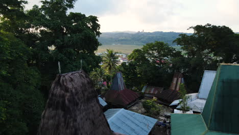 Fly-Over-Traditional-Houses-On-Mountains-Overlooking-Resort-Town-In-West-Sumba,-Indonesia
