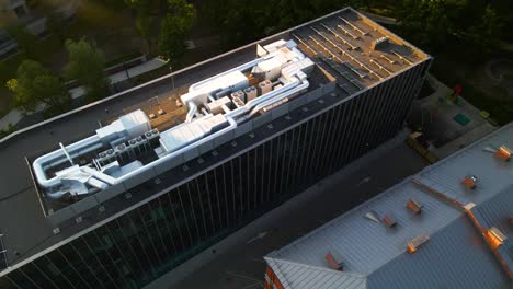 aerial-shot-of-Solar-panels-and-hvac-equipment-on-the-roof-of-the-building-in-Kaunas,-Lithuania