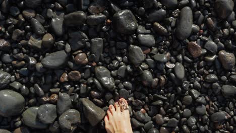 Walking-Barefooted-Looking-Down-with-Point-of-View-On-a-Volcanic-Pebbled-Beach-on-the-Tenerife-Island,-Playa-de-los-Guios