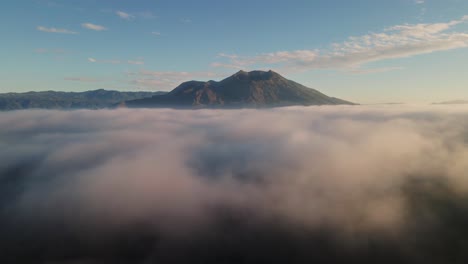 Aerial-view-of-the-Gunung-Batur-volcano-and-misty-lava-fields,-sunrise-in-Bali