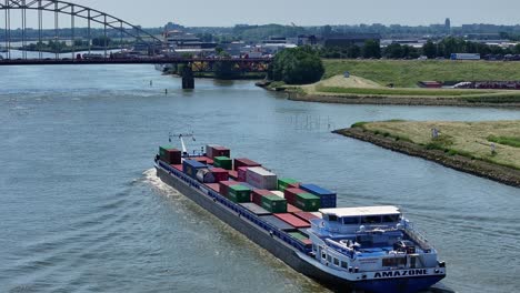 Luftaufnahme-Des-Amazon-Container-Flusstransportschiffs,-Das-Unter-Der-Gel-Brücke-In-Der-Nähe-Der-Stadt-Alblasserdam-Hindurchfährt