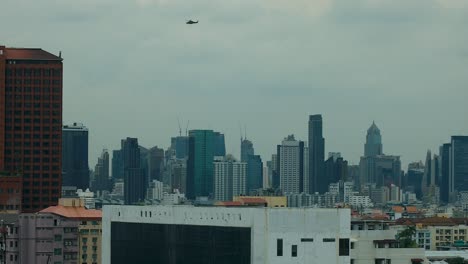 Königlicher-Thailändischer-Militärhubschrauber-Fliegt-über-Die-Skyline-Von-Bangkok,-Thailand,-In-Echtem-4K-DCI