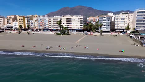 Vista-Aérea-En-Movimiento-Hacia-Atrás-De-La-Playa-De-Estepona,-Destino-Turístico-De-Vacaciones-En-Málaga-España-Andalucia