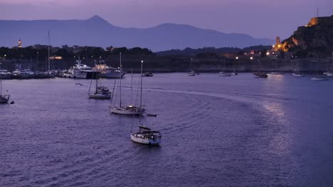 Night-aerial-flying-by-sailing-boats-and-yachts-at-Corfu-with-the-old-fortress-in-the-background