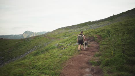 Male-Hiker-With-His-Alaskan-Malamute-Dog-In-Segla,-Norway---wide