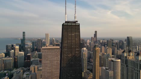 Orbitando-Sobre-Las-Antenas-Del-Centro-John-Hancock-Contra-El-Cielo-Del-Atardecer-En-Chicago,-Illinois,-EE.UU.