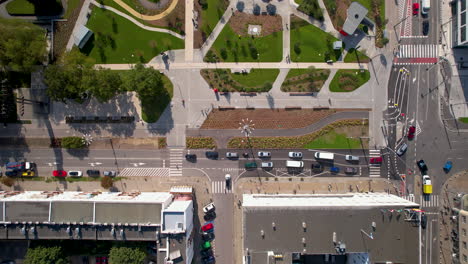 Aerial-top-down---traffic-in-the-city-center-near-a-green-park-and-modern-urban-space---road-intersection-and-good-urban-communication