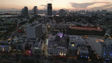 El-Dron-South-Beach-Ocean-Drive-Se-Establece-Al-Anochecer,-El-Horizonte-Del-Atardecer-Y-El-Fondo-De-Las-Nubes