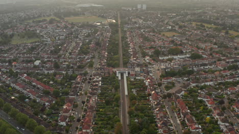 Aerial-shot-of-train-passing-through-expansive-residential-neighbourhood