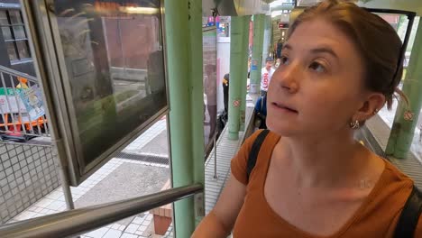 Eine-Touristin-Blickt-Hinaus,-Während-Sie-Die-Rolltreppe-Der-Mittleren-Ebene-In-Hongkong-Entlang-Fährt