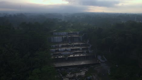 Aerial-view-of-Nature-river-with-waterfall-between-forest-in-misty-morning