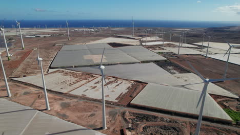 aerial-view-rising-over-wind-turbines-and-greenhouses-in-a-desert-landscape-on-the-island-of-Gran-Canaria-on-a-sunny-day