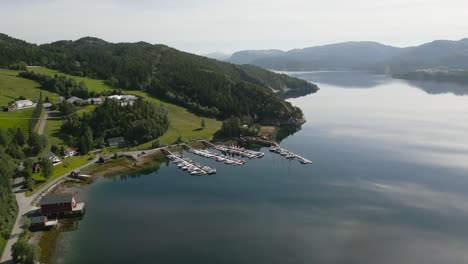 Escena-De-Naturaleza-épica-Del-Tranquilo-Lago-Noruego-Rodeado-De-Un-Frondoso-Bosque,-Aéreo
