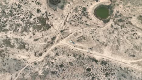 Aerial-View-Of-Camper-Van-Parked-In-Vast-Desert-Landscape