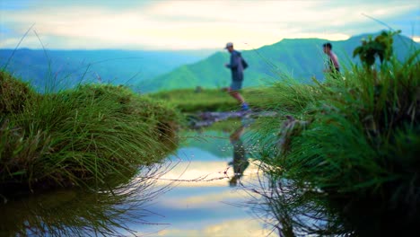 Corredores-De-Senderos-Corriendo-Hacia-Las-Montañas-Con-Un-Hermoso-Empujón-En-Un-Charco-De-ángulo-Bajo