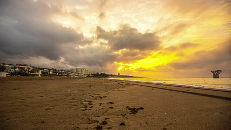 Dramatische-Wolken-über-Dem-Strand:-Ein-Gelb-orangefarbener-Himmel-Im-Zeitraffer