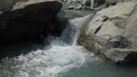 Wasser-Fließt-über-Felsen-Und-Bildet-Einen-Kleinen-Plätschernden-Wasserfall