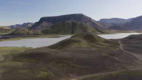 Aufsteigende-Drohnenaufnahme-Des-Kylingavatn-Sees-Mit-Hochlandbergen-An-Einem-Sonnigen-Tag-Auf-Der-Insel-Island