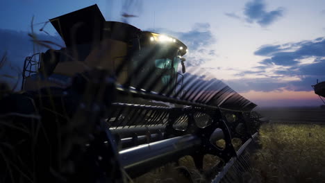 Closeup-of-combine-harvester-and-cutting-platform-with-mowing-fingers,-twilight