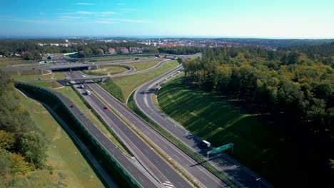 Drone-shot-of-traffic-on-new-build-highway-intersection-and-driving-cars-in-bridge-at-blue-sky---tilt-down