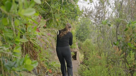 Caucasian-female-tourist-films-hiking-path-and-view-with-camera,-Tenerife