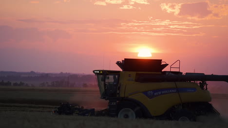 Mähdrescher-Bei-Der-Weizenernte-Vor-Dem-Lebendigen-Sonnenuntergangshimmel,-Luftaufnahmen