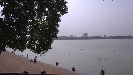 Mucha-Gente-Se-Está-Bañando-Y-Mucha-Gente-Pasa-El-Tiempo-En-La-Orilla-Del-Río-Ganges.