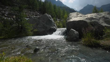 El-Flujo-De-Agua-Sobre-La-Roca-Forma-Una-Pequeña-Cascada-Que-Salpica,-Plano-Amplio