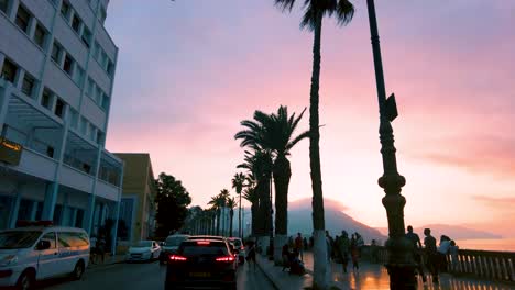 Aufnahme-Der-Gebäude-Der-Stadt-Oran-Mit-Palmen-Am-Straßenrand-Bei-Sonnenuntergang