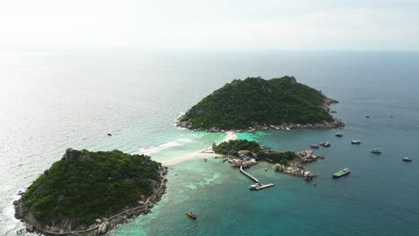 Aerial-view-of-Kho-Tao-island-surrounded-by-coral-reefs-and-marine-life,-Thailand