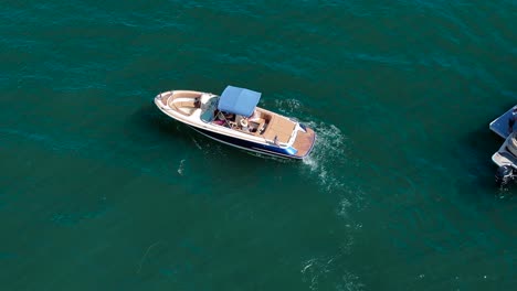 Eine-Kleine,-Luxuriöse-Bootsjacht,-Die-Auf-Einem-Großen,-Klaren,-Blauen-See-Ruht,-Folgt-Aus-Der-Luft