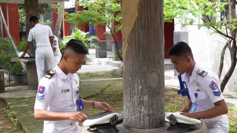 Four-Seafaring-or-Maritime-Vocational-School-students-walk-with-laptops-to-the-park-to-study-outdoors-or-take-classes-in-the-school-garden