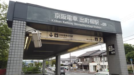 Entrada-A-La-Estación-Demachiyanagi-Del-Metro-De-La-Ciudad-De-Kioto,-Japón,-Calle-Ferroviaria-Y-Tráfico-De-Automóviles-En-Verano,-Ciudad-Japonesa