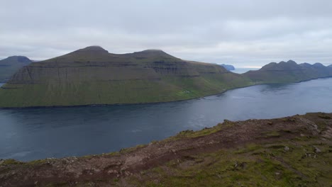 Aerial-panning-right-shot-of-Kalsoy-Island-seen-from-Klakkur-Mountain,-Faroe-Islands