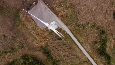 Birds-eye-view-drone-shot-of-a-track-road-near-a-wind-farm-on-the-Hebrides