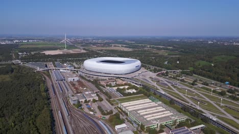 Stunning-aerial-top-view-flight-Bavarian-Munich-Arena-stadium-national-football-soccer-team-Germany,-summer-sunny-blue-sky-day-23