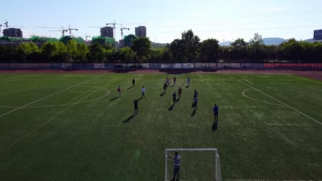 Mini-stadium-with-international-students-playing-football-soccer-in-Beijing-Jioatong-University,-Weihai-sunset