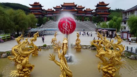 Established-aerial-footage-of-Weihai-Huaxiacheng-cultural-area-water-fountain-with-golden-dragon-in-classic-traditional-Chinese-style