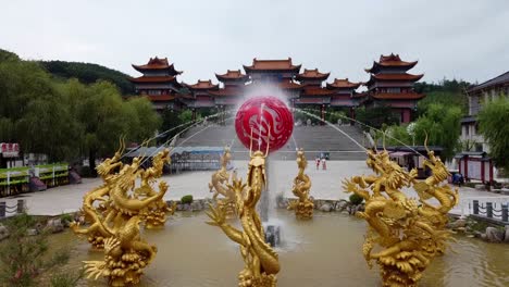 Ascenso-Aéreo-De-Una-Fuente-De-Agua-De-Estilo-Chino-Dragón-En-Weihai-Huaxiacheng,-área-Escénica-Cultural-A-Gran-Escala-Que-Muestra-La-Cultura-Oriental-Clásica.