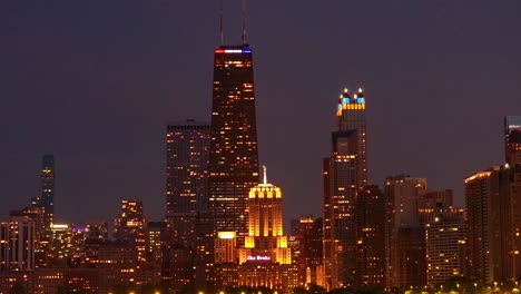 Chicago,-USA-Stadtbild-Skyline-Bei-Nacht,-Zentrale-Gebäude-In-Lichtern-Und-Scheinwerferlicht-Vom-Drake,-Statische-Luftaufnahme