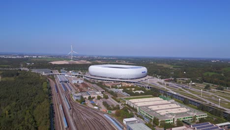 Fantastic-aerial-top-view-flight-Bavarian-Munich-Arena-stadium-national-football-soccer-team-Germany,-summer-sunny-blue-sky-day-23