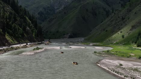 Acercar-Y-Descender-Imágenes-De-Drones-De-Rafting-En-El-Lago-En-La-Zona-Norte-De-Pakistán,-Famosa-Por-Su-Hermosa-Montaña-Verde-Y-Su-Exuberante-Bosque-Verde