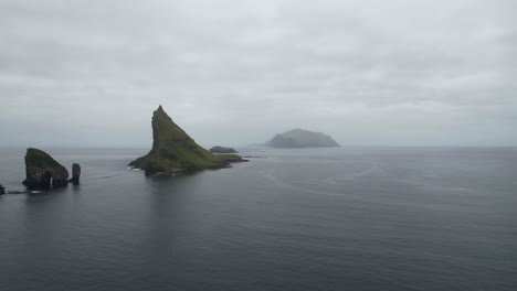 Wide-shot-of-Drangarnir-sea-stacks-and-Tindholmur-islet-with-foggy-Mykines-in-background