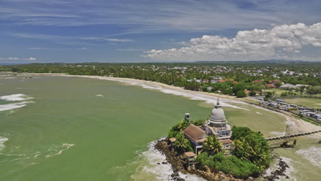 Matara-Sri-Lanka-Luftaufnahme-V1-Filmische-Drohne-Fliegt-Um-Den-Parewi-Duwa-Tempel-Auf-Einer-Felsigen-Insel-Und-Fängt-Den-Langen-Sandstrand-Und-Die-Aussicht-Auf-Das-Dorf-Kotuwegoda-Ein-–-Aufgenommen-Mit-Mavic-3-Cine-–-April-2023