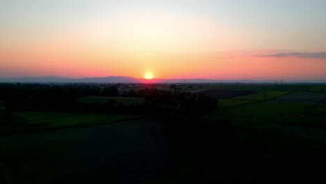 Glühender-Sonnenuntergang-über-Den-Grünen-Feldern-In-Der-Nähe-Der-Landschaft