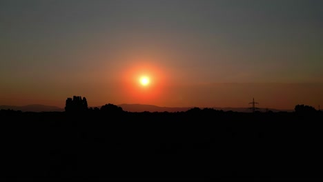 Roter-Sonnenuntergangshimmel-über-Silhouettierter-Landschaft-Am-Abend
