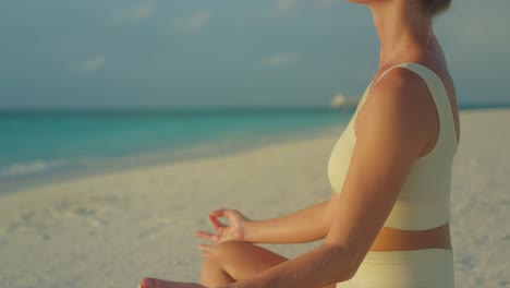 Mujer-Disfrutando-Del-Sol-De-La-Mañana-En-La-Playa-Mientras-Está-Sentada-En-Una-Pose-Fácil-De-Yoga