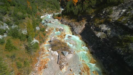 Drone-flight-bird's-eye-view,-showing-the-colorful-of-Karwendelbach-river-in-the-Karwendel-mountains-of-Austrias-Tyrol,-very-close-to-Scharnitz,-recorded-in-autumn
